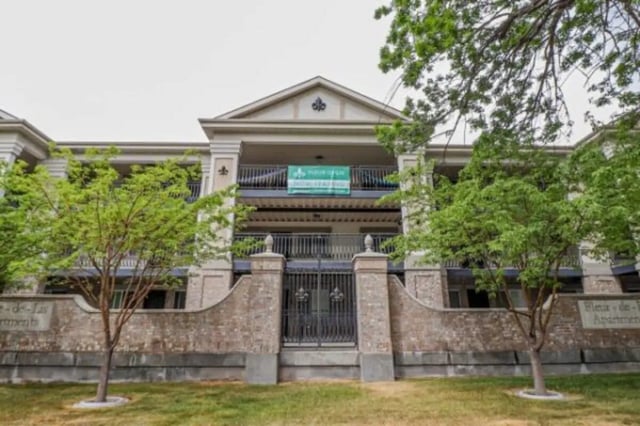 Apartment building entrance with brick gate and greenery exterior at Fleur De Lis Apartments in Provo Student Accommodation
