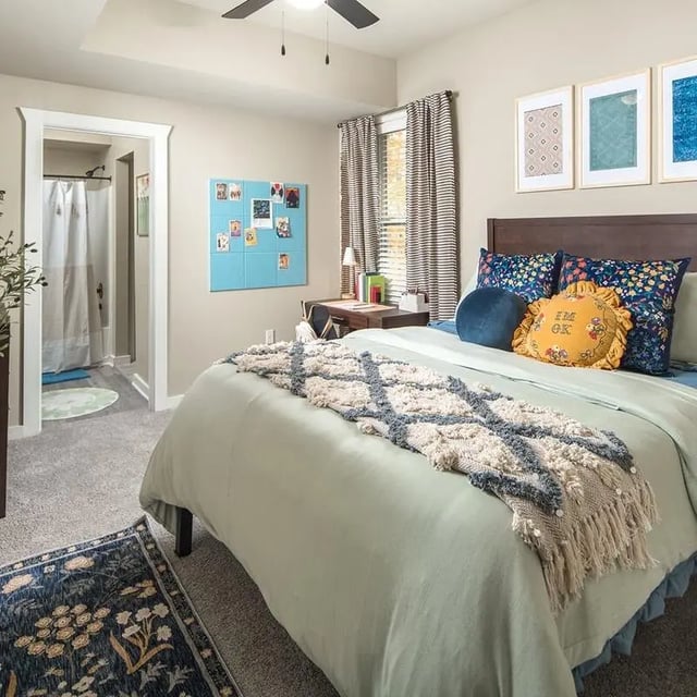 Bed with patterned throw desk and bathroom Bedroom at Highpointe in Boone Student Accommodation