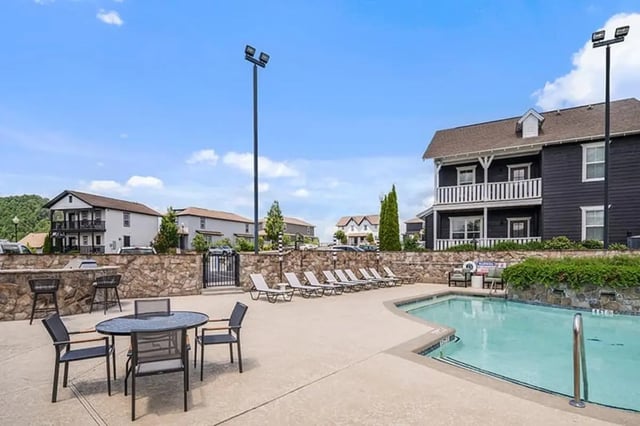 Pool lounge chairs dining tables exterior living area at Highpointe in Boone Student Accommodation