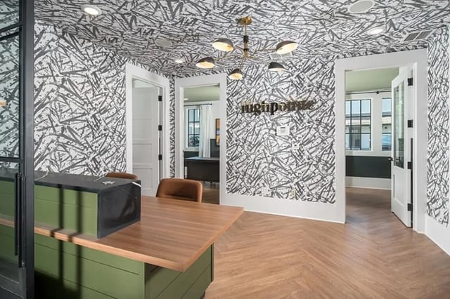 Front desk with chairs and abstract wallpaper reception area at Highpointe in Boone Student Accommodation