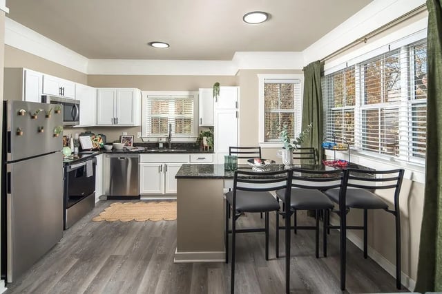 Stainless steel refrigerator white cabinets granite island bar stools kitchen at Highpointe in Boone Student Accommodation
