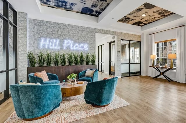 Blue chairs and coffee table in lounge area at Hill Place Apartments in Fayetteville Student Accommodation