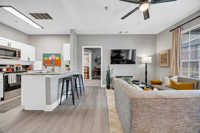 Kitchen with bar stools and living room Living Room at Knights Circle in Orlando Student Accommodation