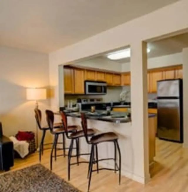 Bar stools and kitchen island open to living area kitchen at Knollwood Apartments in Kalamazoo Student Accommodation