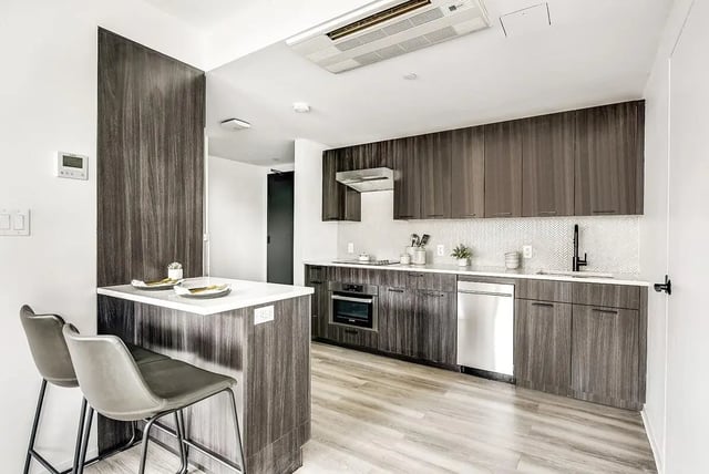 Kitchen with island two bar stools and appliances kitchen at Monarch Heights Apartments
