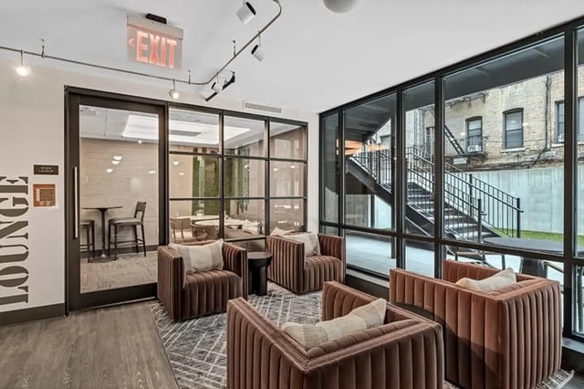 Brown plush chairs windows exit sign lounge area at Monarch Heights Apartments