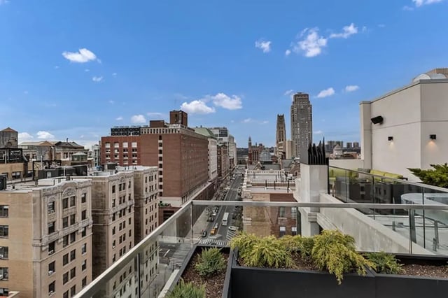 Balcony with plants overlooks city skyline exterior at Monarch Heights Apartments