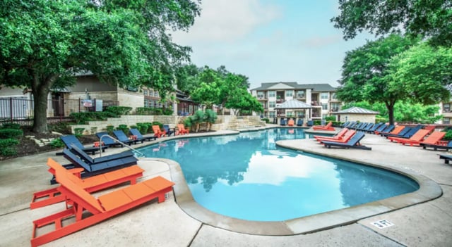 Swimming pool with lounge chairs and buildings exterior at Hillside Ranch in San Marcos Student Accommodation