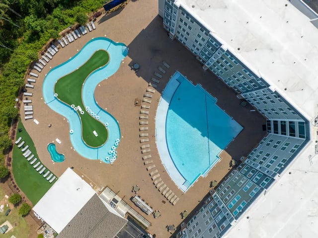 Pool area with lounge chairs and buildings exterior at The Ridge Clemson in Central Student Accommodation
