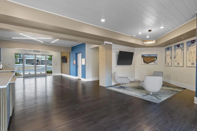 Chairs TVs and blueprints in a lobby living room at The Ridge Clemson in Central Student Accommodation
