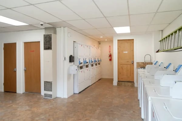 Row of washing machines and lockers laundry room at Monticello Apartments in Provo Student Accommodation
