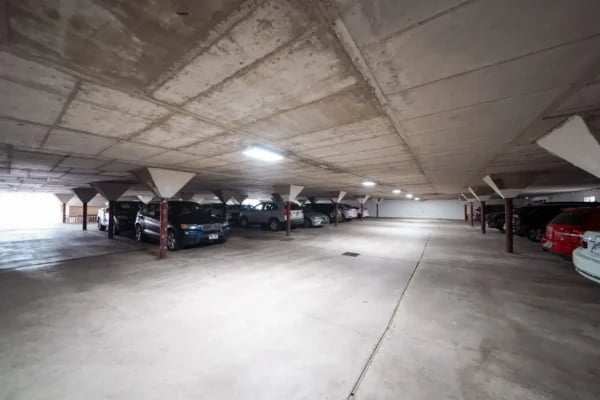 Cars parked in a concrete underground parking lot exterior at Monticello Apartments in Provo Student Accommodation