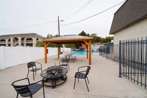 Patio furniture fire pit pool under gazebo outdoor area at Monticello Apartments in Provo Student Accommodation