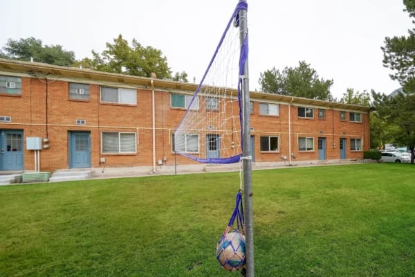 Volleyball net with ball grassy yard exterior at Monticello Apartments in Provo Student Accommodation