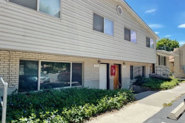 Apartment building with white siding brick lower level exterior at Monticello Apartments in Provo Student Accommodation