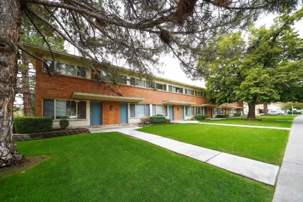 Brick building blue doors green lawns exterior at Monticello Apartments in Provo Student Accommodation