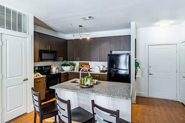 Island kitchen with granite counter and stools kitchen at Pointe San Marcos in San Marcos Student Accommodation