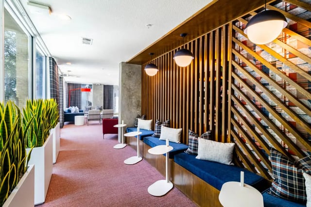 Blue seating with pillows and white tables common area at Pointe San Marcos in San Marcos Student Accommodation