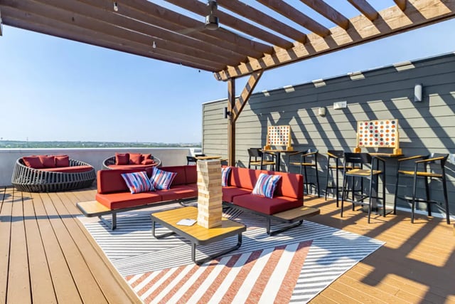 Red sofas coffee table Jenga game outdoor lounge at Pointe San Marcos in San Marcos Student Accommodation