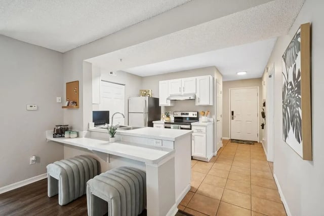 Counter stools sink refrigerator oven kitchen and dining area at ReNew Tallahassee in Tallahassee Student Accommodation