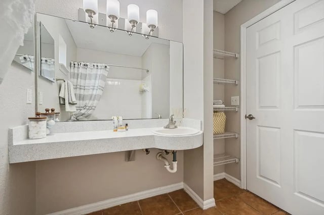 Sink vanity mirror shower curtain shelving bathroom at ReNew Tallahassee in Tallahassee Student Accommodation