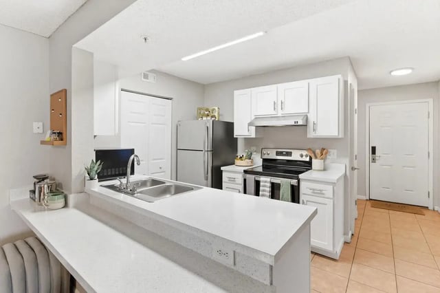 Kitchen with white cabinets stainless steel appliances kitchen island kitchen at ReNew Tallahassee in Tallahassee Student Accommodation