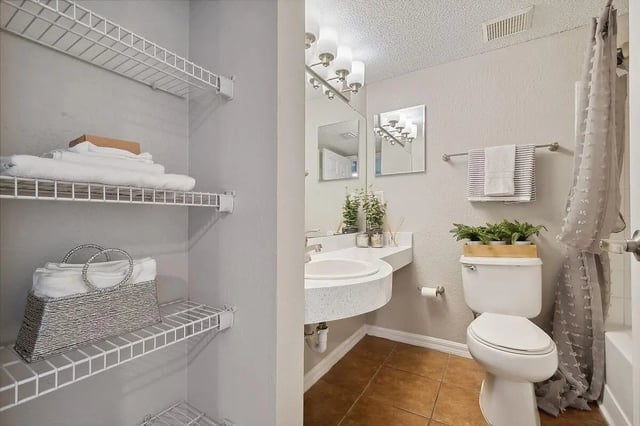 Shelves with towels basket sink toilet bathroom at ReNew Tallahassee in Tallahassee Student Accommodation