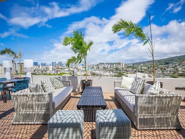 Rooftop lounge with sofas and city view exterior at Hale Mahana in Honolulu Student Accommodation