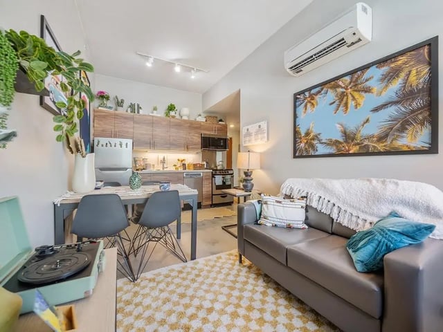 Sofa, table, kitchen, and artwork Living room at Hale Mahana in Honolulu Student Accommodation