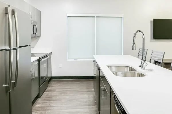 Stainless steel appliances kitchen island with sink kitchen at The Factory Student Housing in Logan Student Accommodation