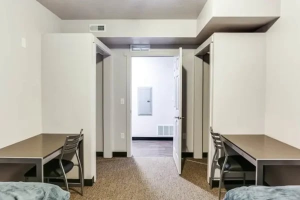 Two desks with chairs and closets bedroom at The Factory Student Housing in Logan Student Accommodation