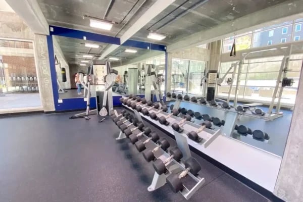 Dumbbells weight machines and mirrors gym at The Factory Student Housing in Logan Student Accommodation