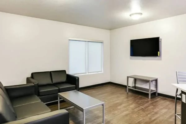 Black sofas coffee table mounted TV living room at The Factory Student Housing in Logan Student Accommodation