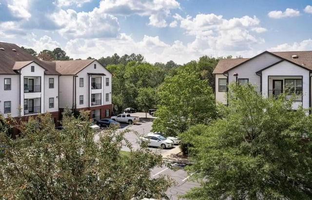 Apartment buildings cars parked trees exterior at Lakeside Student Living in Starkville Student Accommodation