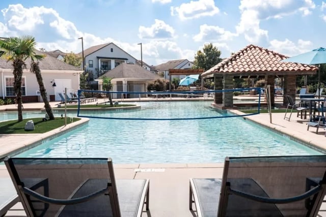 Pool with volleyball net and lounge chairs exterior at Lakeside Student Living in Starkville Student Accommodation