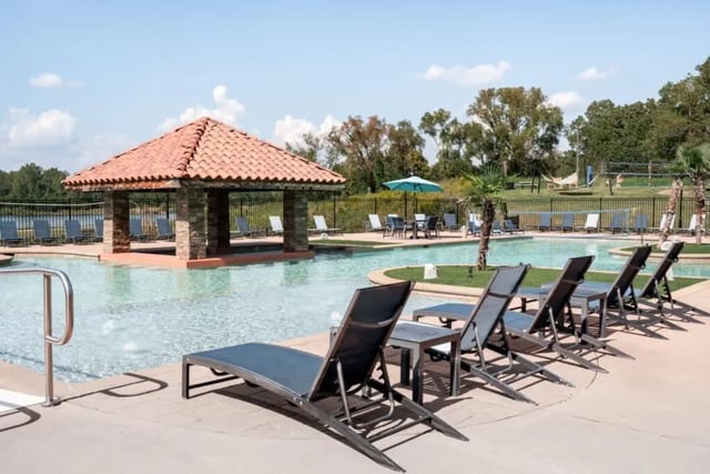 Poolside lounge chairs near swim up bar exterior at Lakeside Student Living in Starkville Student Accommodation