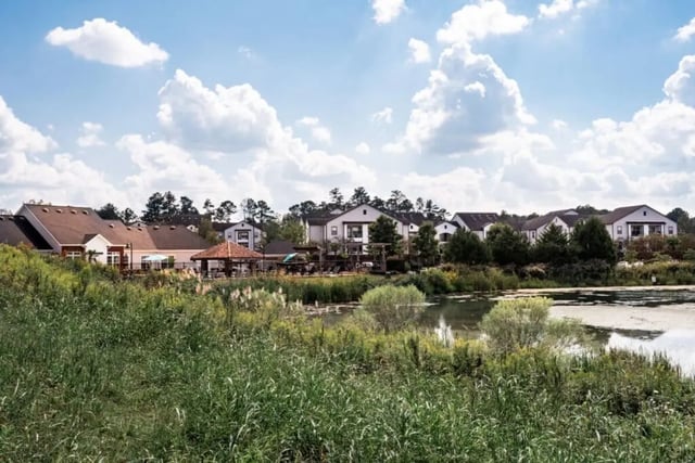 Apartment buildings next to a pond exterior at Lakeside Student Living in Starkville Student Accommodation