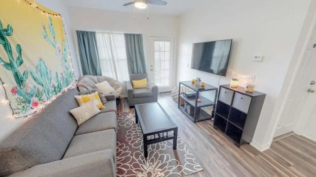 Gray sectional sofa coffee table TV living room at Lakeside Student Living in Starkville Student Accommodation