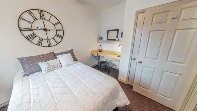 Bed desk chair and clock bedroom at Lakeside Student Living in Starkville Student Accommodation