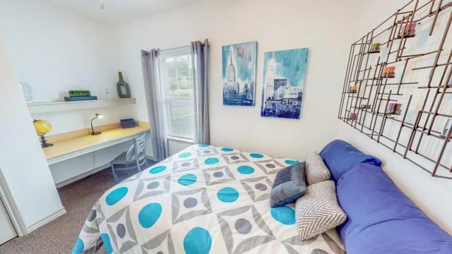 Bed with patterned comforter desk and globe bedroom at Lakeside Student Living in Starkville Student Accommodation