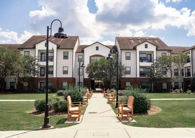 Apartment building with pathway and benches exterior at Lakeside Student Living in Starkville Student Accommodation