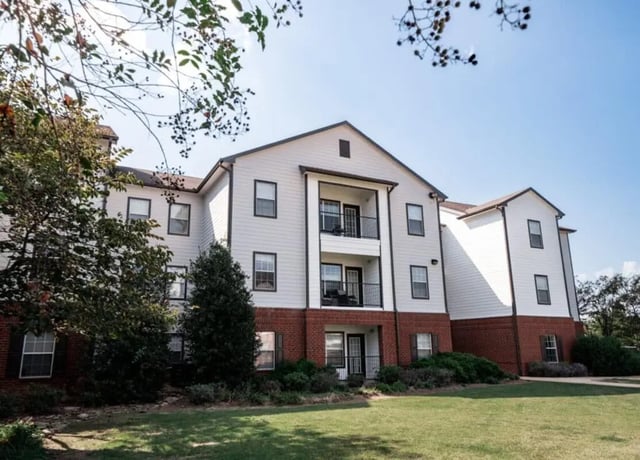 Student housing building with balconies and grass exterior at Lakeside Student Living in Starkville Student Accommodation