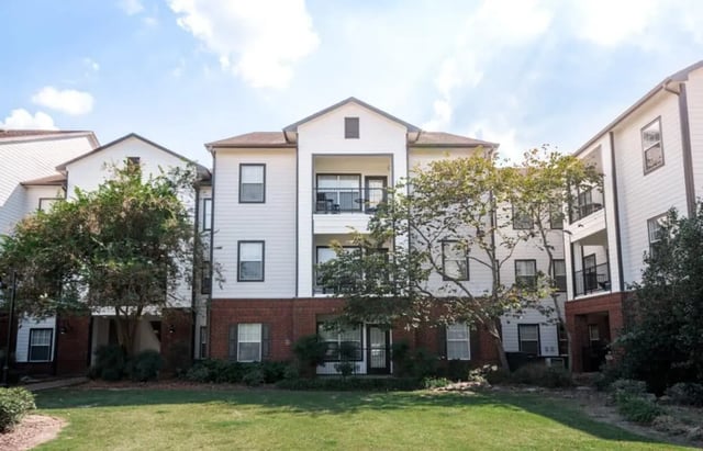 Apartment building with balconies and green lawn Exterior at Lakeside Student Living in Starkville Student Accommodation