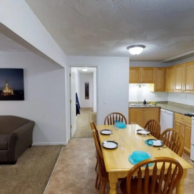 Dining table chairs kitchen living room exterior at The Pines in Rexburg Student Accommodation