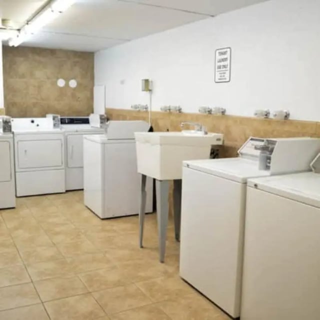 Multiple washers dryers and utility sink laundry area at The Pines in Rexburg Student Accommodation
