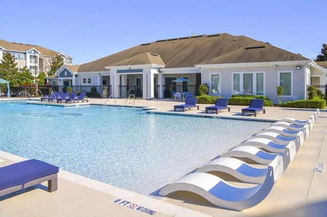 Pool with lounge chairs and building exterior at The Hudson in Albany Student Accommodation