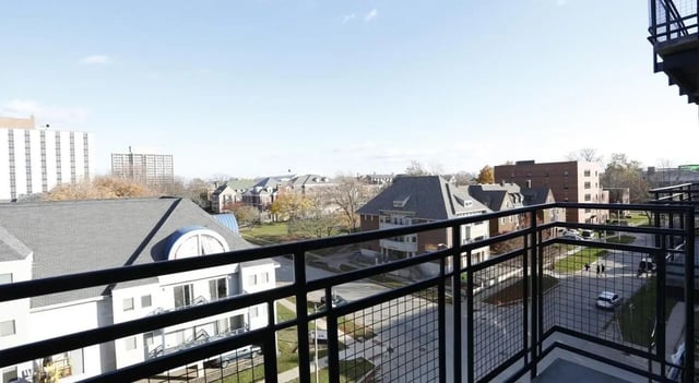 Railing overlooks buildings and street view exterior at Lancaster Apartments in Champaign Student Accommodation