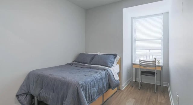 Bed desk and chair in room bedroom at Lancaster Apartments in Champaign Student Accommodation