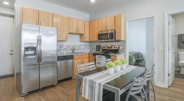 Stainless refrigerator dining table kitchen and bedroom exterior at Lancaster Apartments in Champaign Student Accommodation