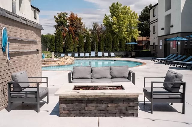 Outdoor seating area by pool and lounge chairs exterior at The Crestwood in Provo Student Accommodation